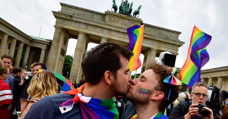 TOPSHOT - Two men kiss as they attend a rally of gays and lesbians in front of the Brandenburg Gate in Berlin on June 30, 2017. The German parliament legalised same-sex marriage, days after Chancellor Angela Merkel said she would allow her conservative lawmakers to follow their conscience in the vote. / AFP PHOTO / Tobias SCHWARZ (Photo credit should read TOBIAS SCHWARZ/AFP/Getty Images)