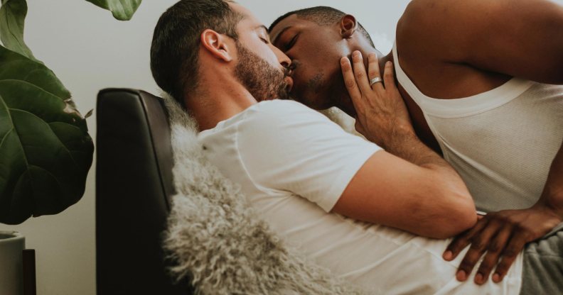 Two men kissing on a couch