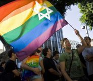 An Israeli man waves a Pride rainbow flag bearing the Star of David