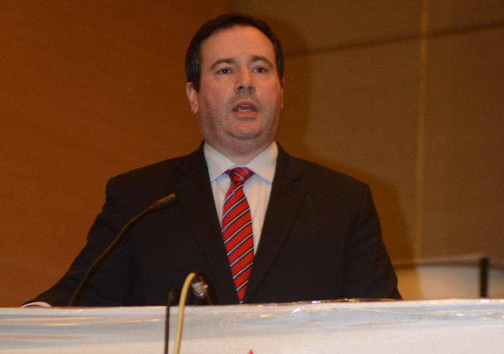 Jason Kenney speaking into a microphone