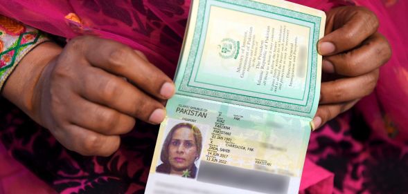 A close up of hands holding a non-binary passport.