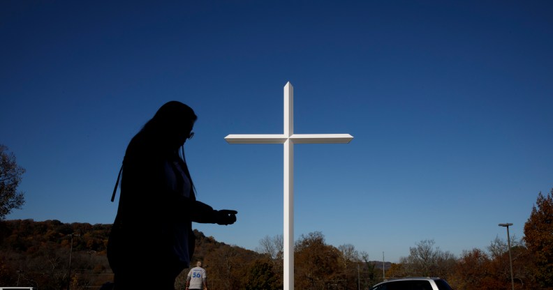 A silhouette against a white church cross