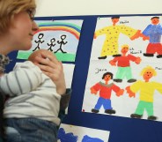 A woman holding a baby looking at drawings. She is at Germany's first gay parent counselling centre.