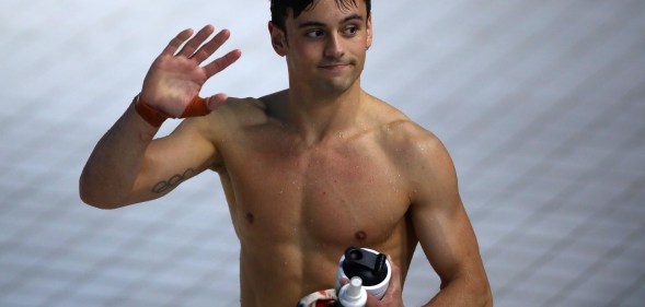 Tom Daley shirtless and waving