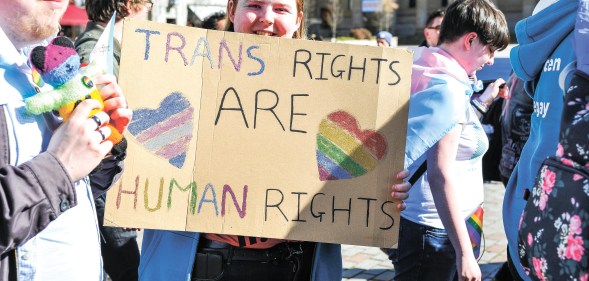 A participant is seen holding a placard during the 2019 Trans Pride march in Dundee.