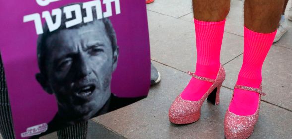 Members of the LGBT community hold a banner reading in Hebrew 'A homophobic Racist Has to Quit' during a rally against Israel's Education Minister Rafi Peretz following his remarks on gay conversion therapy, in the Israeli coastal city of Tel Aviv on July 14, 2019.