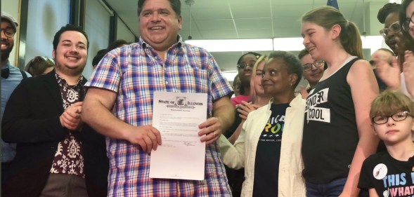 Illinois Governor J.B. Pritzker holds his executive order alongside Chicago Mayor Lori Lightfoot.