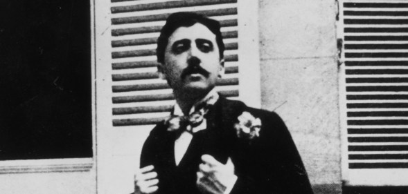 French author Marcel Proust sitting outside a window.