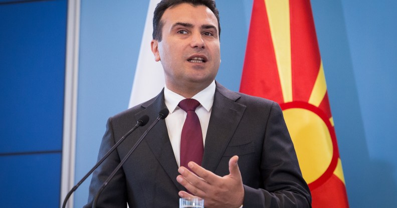 Zoran Zaev speaking in front of a North Macedonia flag.