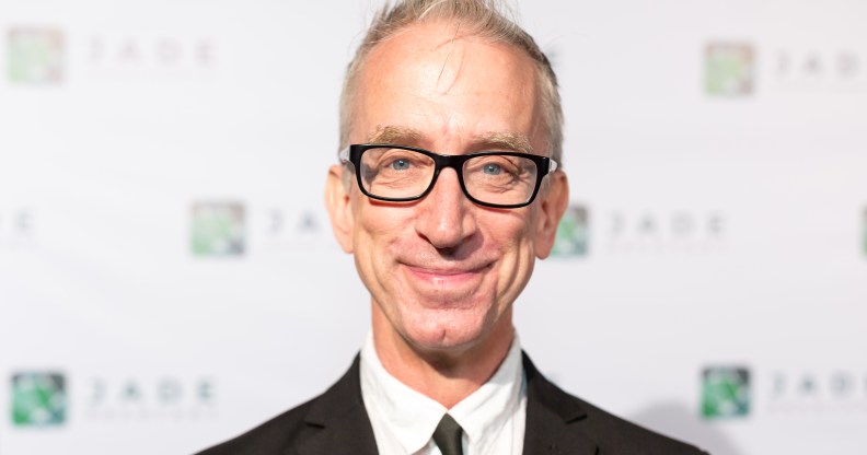 Andy Dick smiling, wearing a suit and black tie