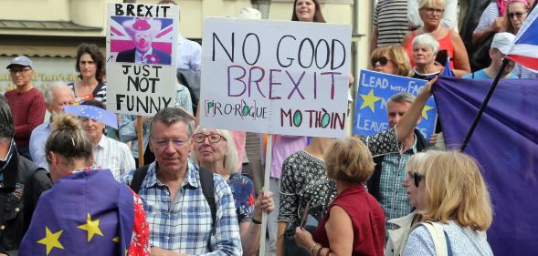 Protestors hold placards as they look on outside the venue for talks between the British Prime Minister and EU Commission president in Luxembourg. (FRANCOIS WALSCHAERTS/AFP/Getty Images)