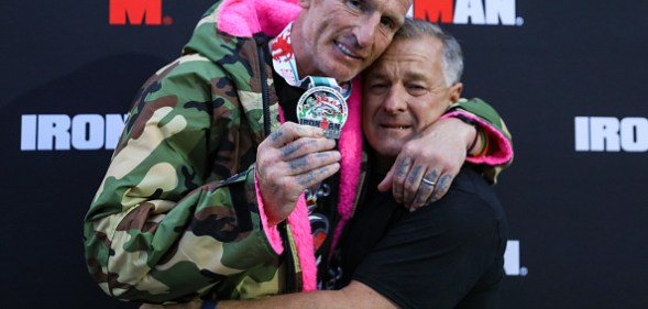 Gareth Thomas shows his finishers medal as he celebrates with his partner on completing his first Ironman triathlon. (Huw Fairclough/Getty Images)