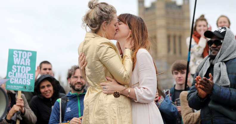 Tasmin and Melissa embrace after they received a blessing ahead of their wedding day, surrounded by activists from the climate change group Extinction Rebellion, during a demonstration on Westminster Bridge