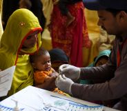 A Pakistani paramedic takes a blood sample from a baby for a HIV test in Ratodero