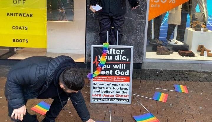 rainbow flags around street preacher