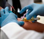 A technician extracts blood from a patient for an HIV test.