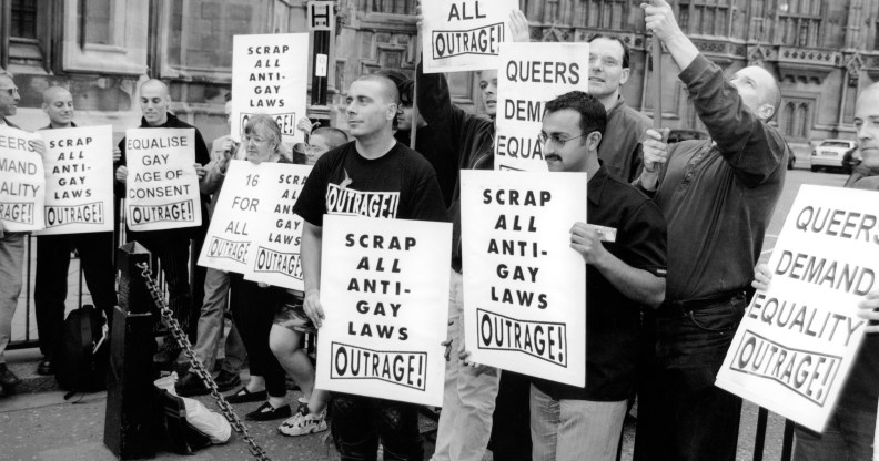 protesters holding placards with messages reading 'equalise gay age of consent' and scrap all anti-gay laws'