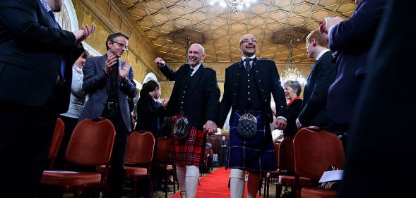 Joe Schofield and Malcolm Brown from Tullibody, Clackmannanshire are married by Ross Wright, Celebrant from Humanist Society Scotland in the Trades Hall shortly after midnight in front of friends and family in one of the first same-sex and belief category weddings in Scotland on December 31, 2014 in Glasgow, Scotland.