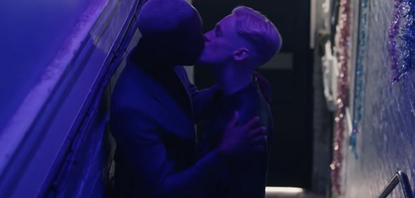 Two men kissing in a stairwell in H&M advert