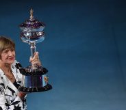 Former Australian tennis player Margaret Court poses with a replica of the trophy to commemorate 50 years of her Australian grand slam win