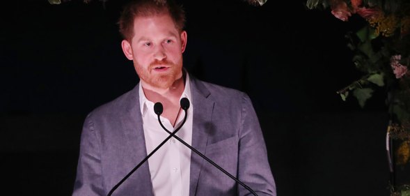 Prince Harry speaking into two microphones