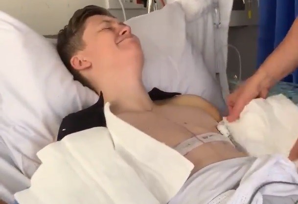 The powerful clip shows bandages being carefully removed in hospital after top surgery.