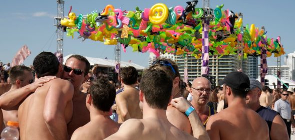 A group of men hugging at the Winter Party Festival on Miami Beach. At least one attendee in 2020 acquired the coronavirus, according to organisers. (Jeffrey Greenberg/Universal Images Group via Getty Images)