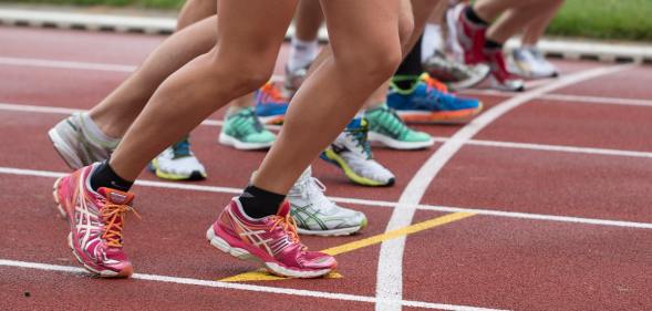 Women line up to sprint on a running track