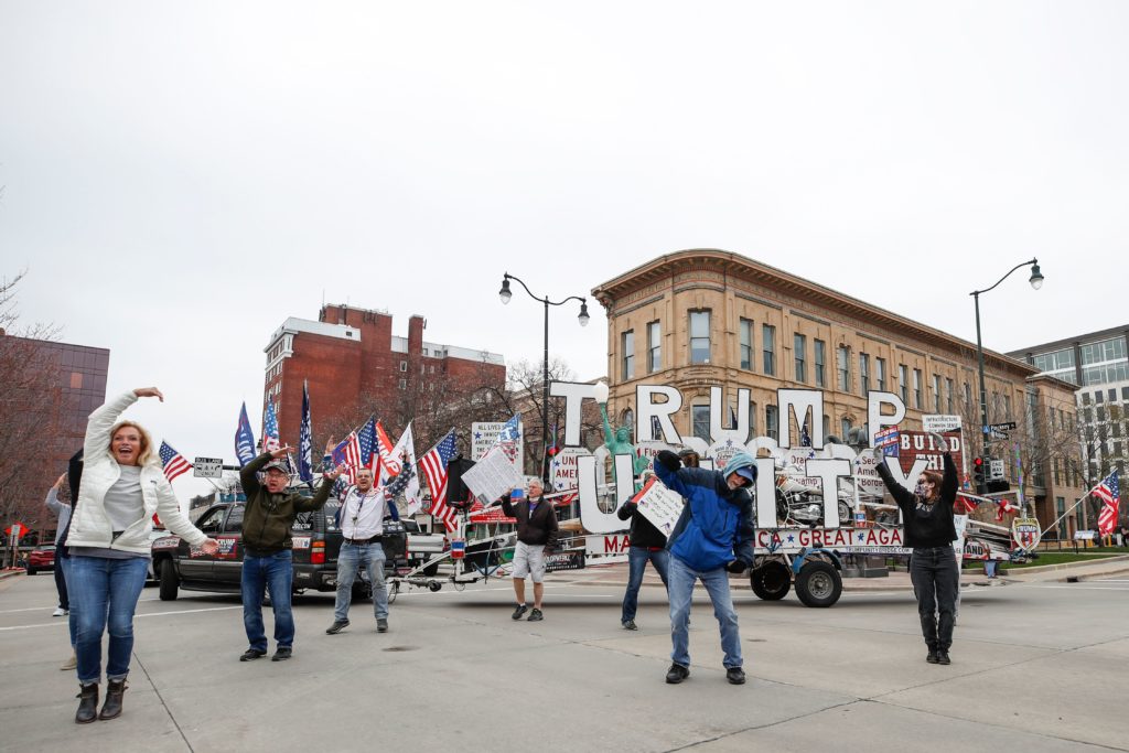 People hold signs during a protest against the coronavirus shutdown in front of State Capitol in Madison, Wisconsin, on April 24 2020. (KAMIL KRZACZYNSKI/AFP via Getty Images)