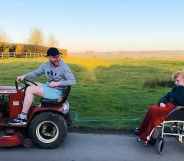 Tommy Ferris tows his grandmother's wheelchair on his sit-down lawnmower. (Screen capture via BBC)