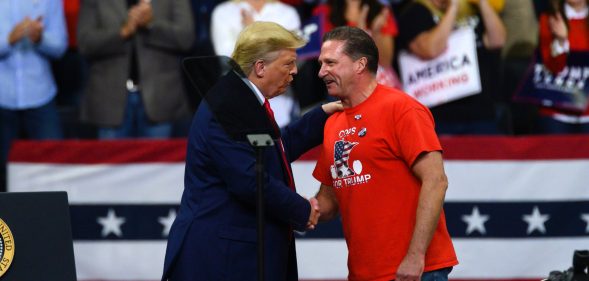 US president Donald Trump shakes hands with Minneapolis Police Union head Bob Kroll on stage during a campaign rally at the Target Center on October 10, 2019 in Minneapolis, Minnesota