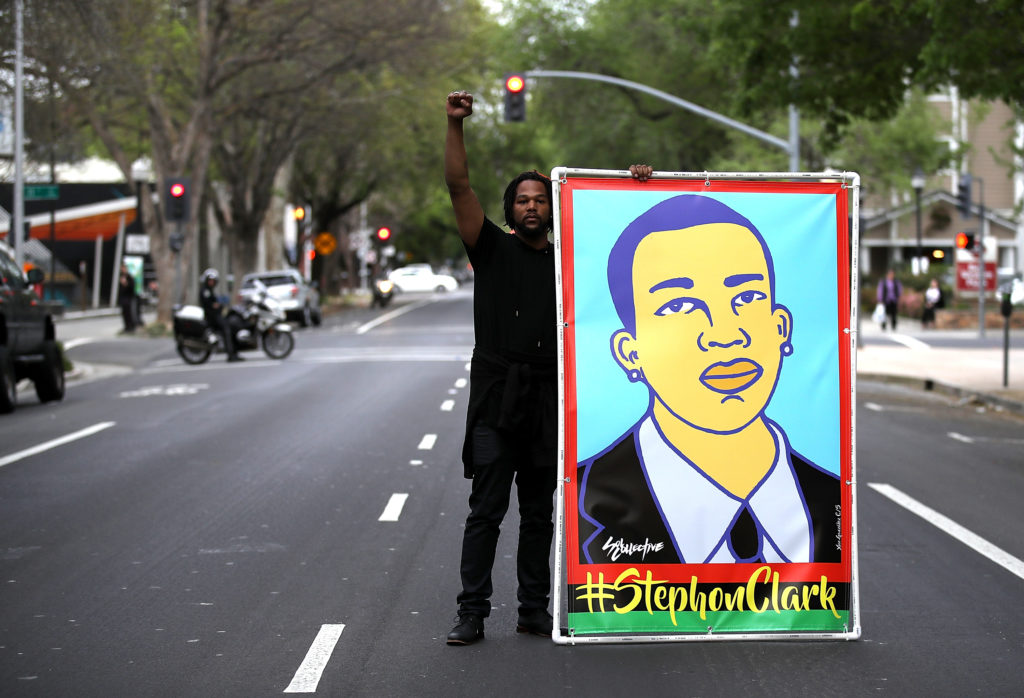 A Black Lives Matter protester holds an illustration of Stephon Clark during a march on April 4, 2018 in Sacramento, California. (Justin Sullivan/Getty Images)