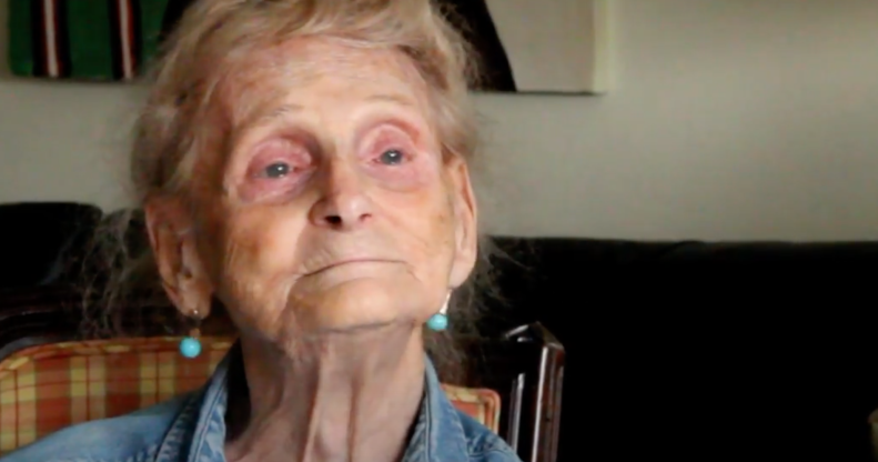 Robina Asti smiles in a denim shirt as she sits on a chair