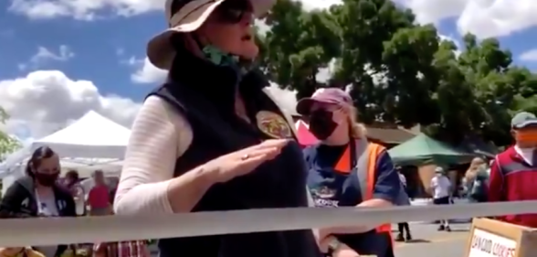 Gail Hayden, head of the California Farmer’s Market Association, scolds a gay vendor for handing out LGBT+ Pride flags. (Screen capture via Twitter)