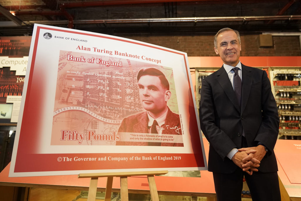 Mark Carney in front of a large illustration of the Alan Turing note