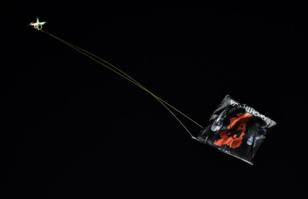 A flag with Albanian national symbols attached to a remotely operated drone flies in the stadium during the EURO 2016 group I football match between Serbia and Albania in Belgrade on October 14, 2014. (ANDREJ ISAKOVIC/AFP via Getty Images)