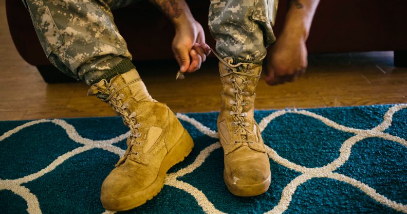 Army Sergeant Shane Ortega laces up boots before posing for a portrait at home at Wheeler Army Airfield on March 26, 2015 in Wahiawa, Hawaii.