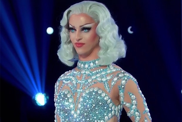 Miz Cracker in a blue wig and jewelled blue bodysuit