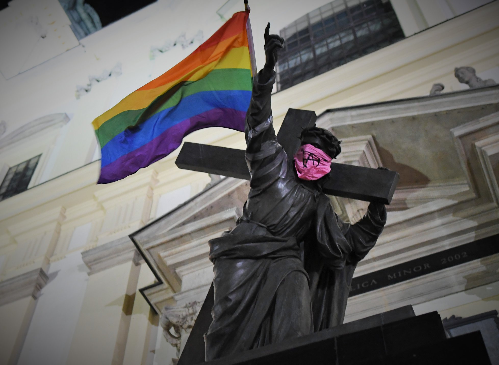 Statue of Jesus carrying Pride flag and wearing anarchist bandana