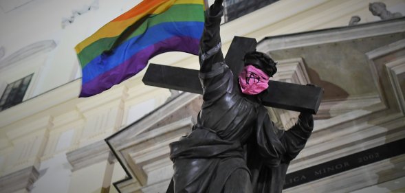 Statue of Jesus carrying Pride flag and wearing anarchist bandana