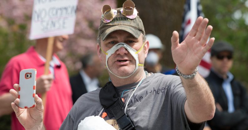 Man wearing a face mask cut out so that his mouth is exposed