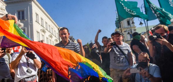 Far-right protesters attempt to burn a rainbow flag as they protest against the LGBT community on August 16, 2020 in Warsaw, Poland.