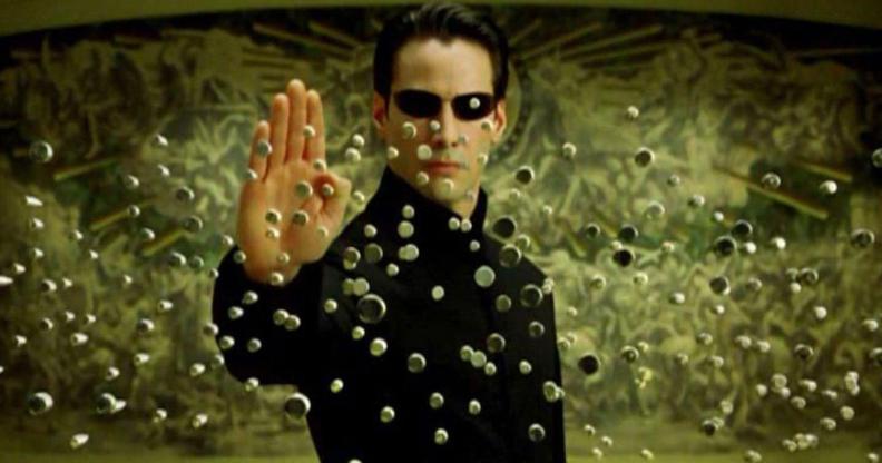 Neo holding up his palm to stop a raft of bullets