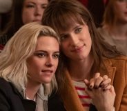 Kristen Stewart and Mackenzie Davis holding hands in Happiest Season