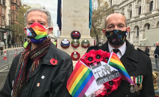 Peter Tatchell and David Bonney holding a rainbow poppy wreath at the Cenotaph