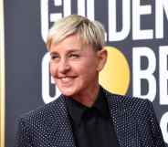 Ellen DeGeneres smile while wearing a grey suit jacket