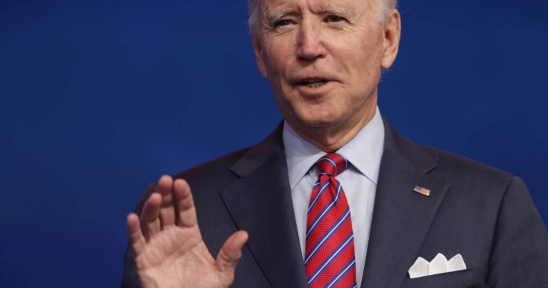 Joe Biden holding up one hand, making a vow