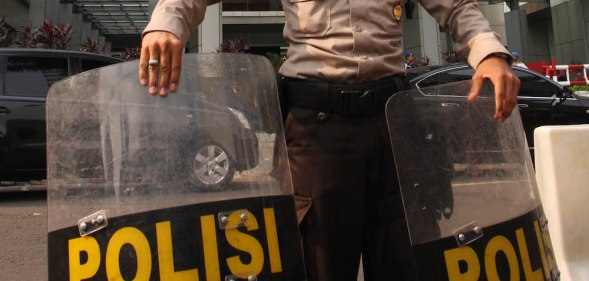 A police officer stands guard at the front of the Marriott hotel in Jakarta, Indonesia