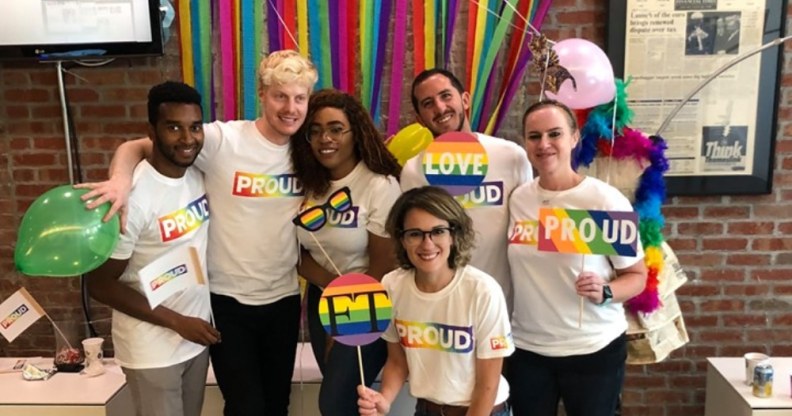 Members of Pride FT, the LGBT+ wing of the Financial Times, pose with rainbow 'proud' t-shirts and rainbow FT signs