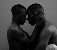 Two Black men about to kiss